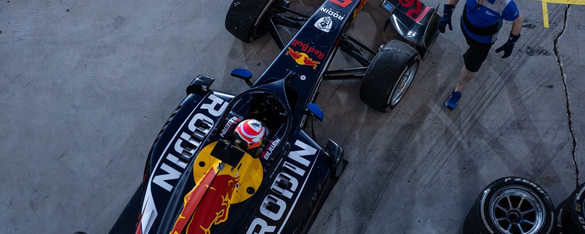 Top-down view of dark blue car with Rodin and Red Bull sponsorships on it.