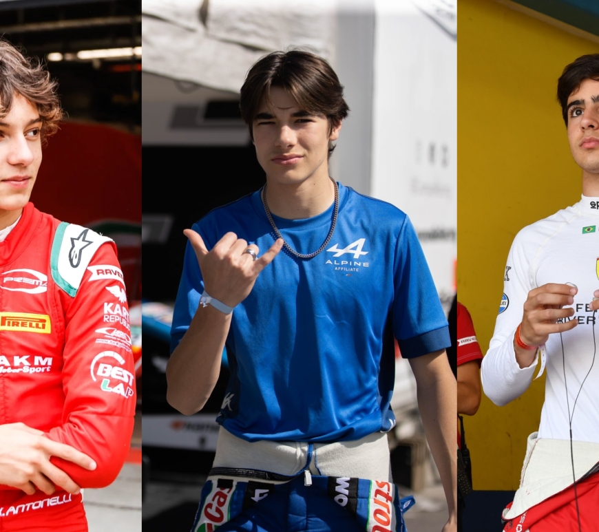 A boy in a red racing suit with his arms crossed looks to his left; a boy in a blue Alpine Affiliate top with a race suit at his waist makes a shaka gesture with his right hand while looking at the camera; a boy in a white Sparco race top holds two earbuds, one in each hand, while looking out slightly to his right