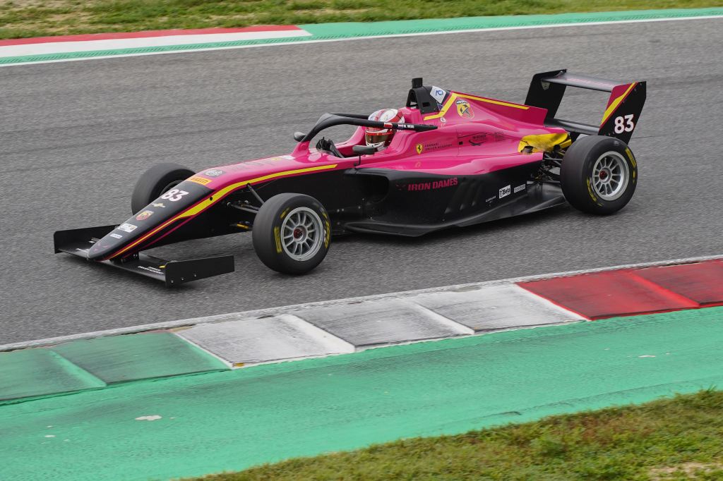 A pink Italian F4 car on track