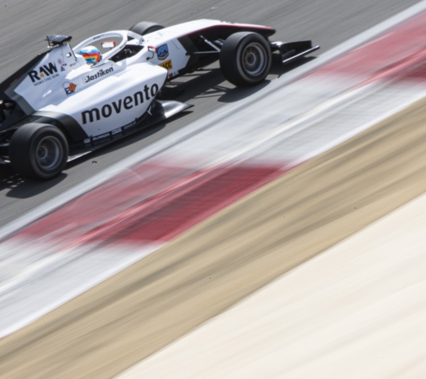 A white and black F3 car in the top-left corner of the image alongside a kerb, which blurs into the beige runoff to the bottom right