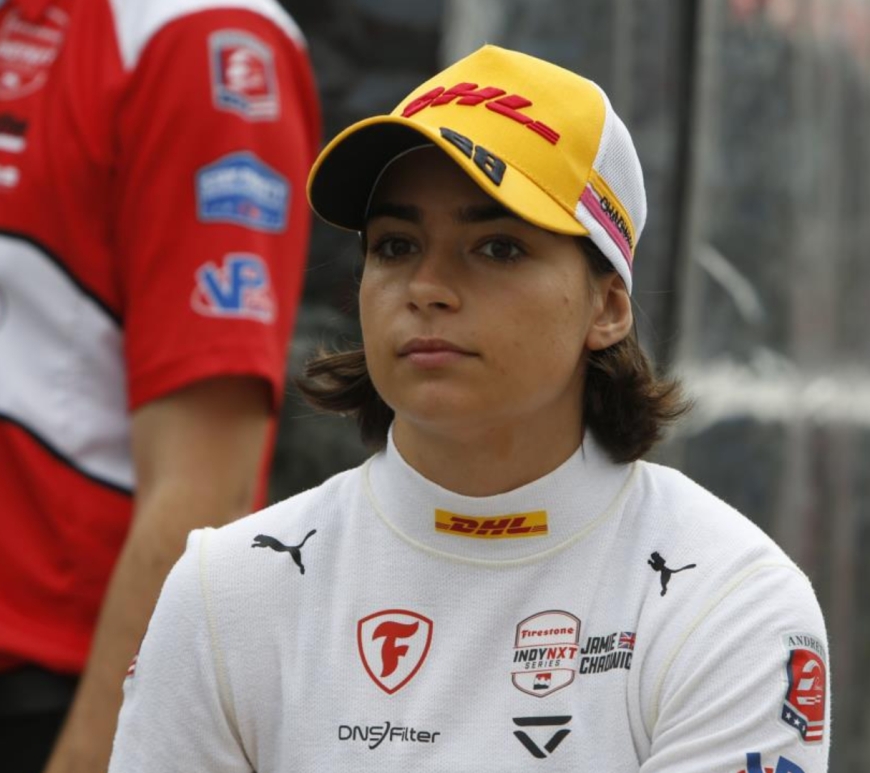 Jamie Chadwick staring at the camera in a yellow DHL cap